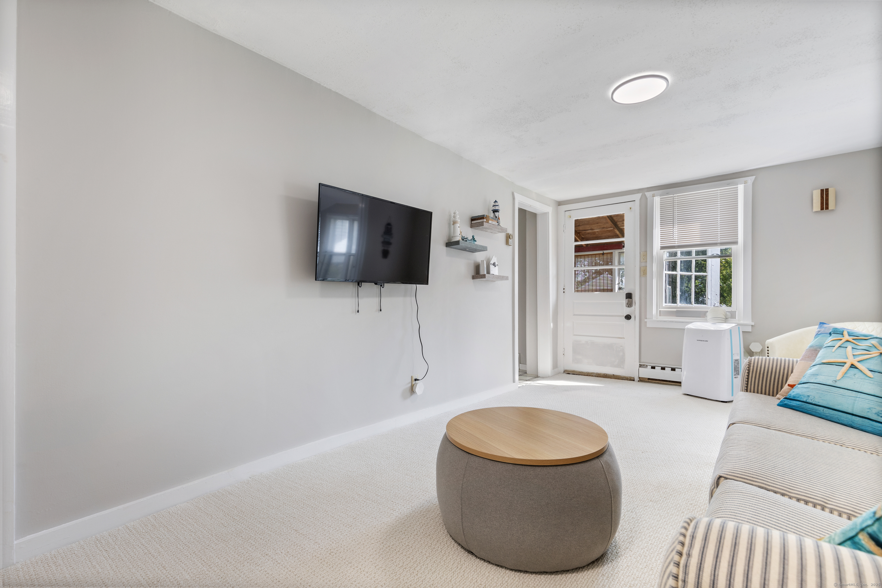 176 Shore Road, Unit B Clinton, CT 06413 - Photo 14 of 24 a living room with furniture and a flat screen tv