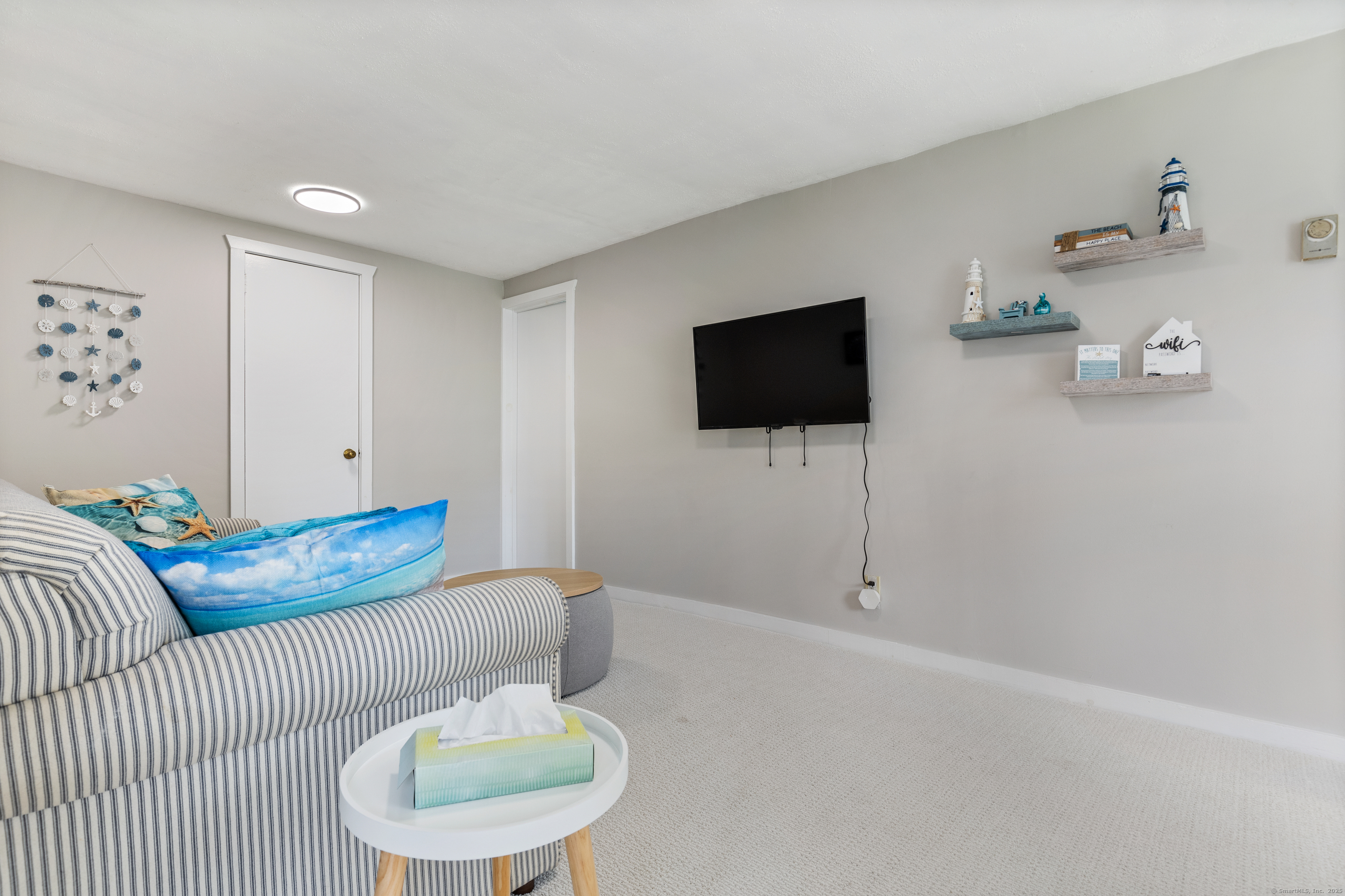 176 Shore Road, Unit B Clinton, CT 06413 - Photo 15 of 24 a living room with furniture and a flat screen tv