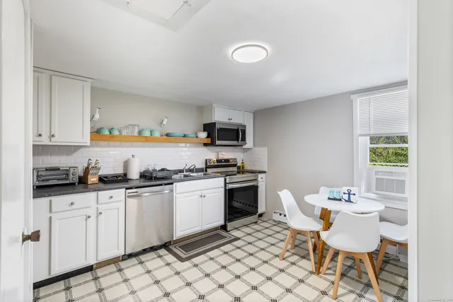 a kitchen with granite countertop white cabinets and stainless steel appliances