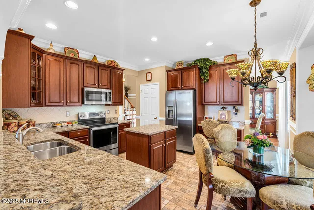 a kitchen with stainless steel appliances granite countertop a stove top oven a sink dishwasher a dining table and chairs with wooden floor