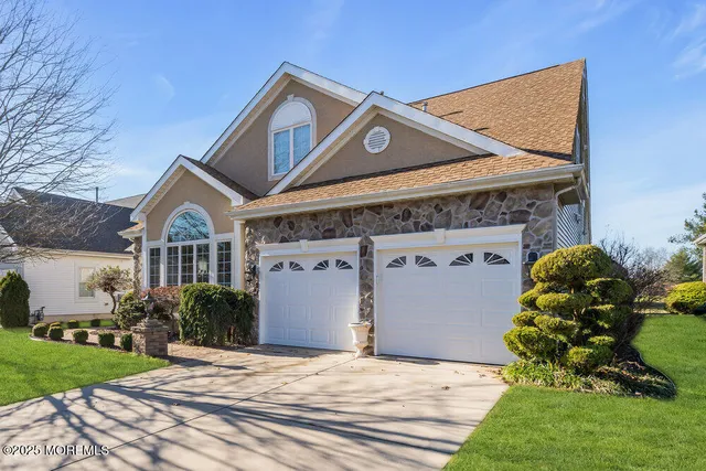a front view of a house with a garden and plants