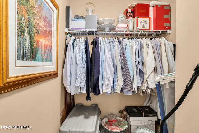 a view of walk in closet with clothes and shoes