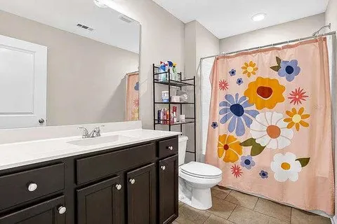 a bathroom with a granite countertop toilet sink and mirror