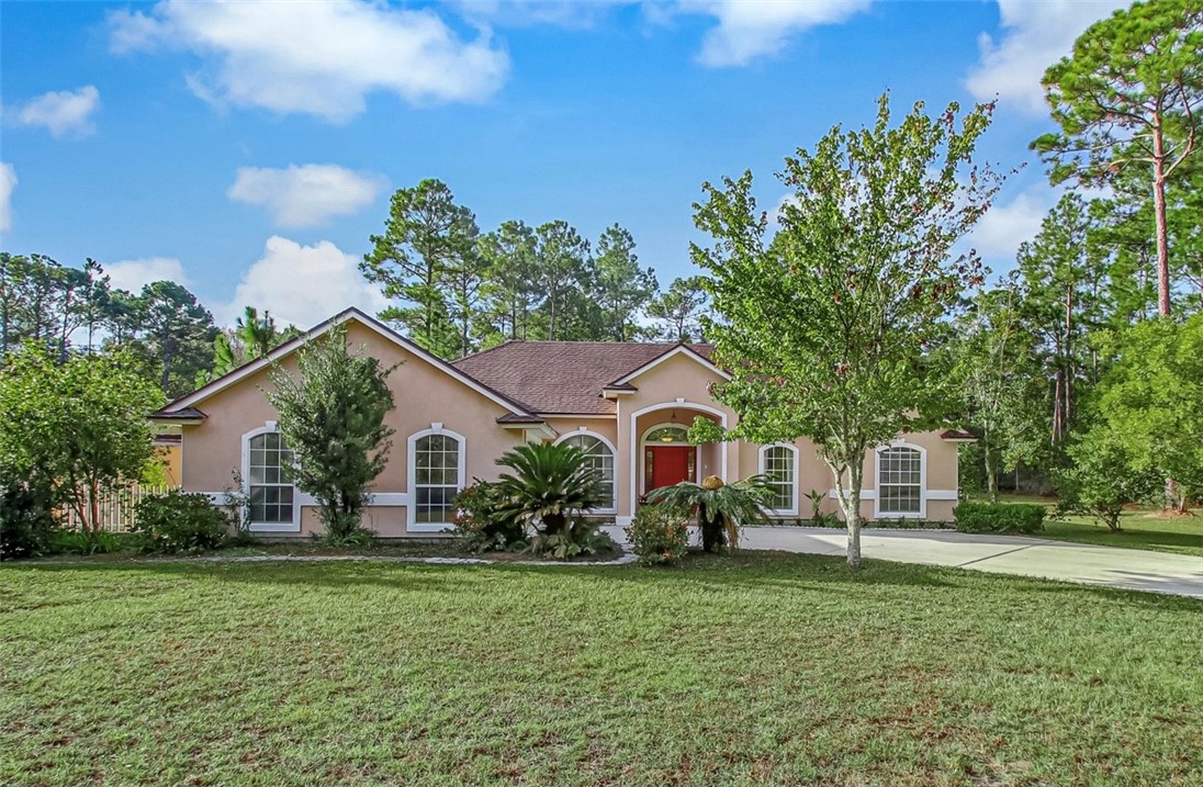 96372 Green Pine Road Yulee, FL 32097 - Photo 1 of 28 a front view of a house with a garden