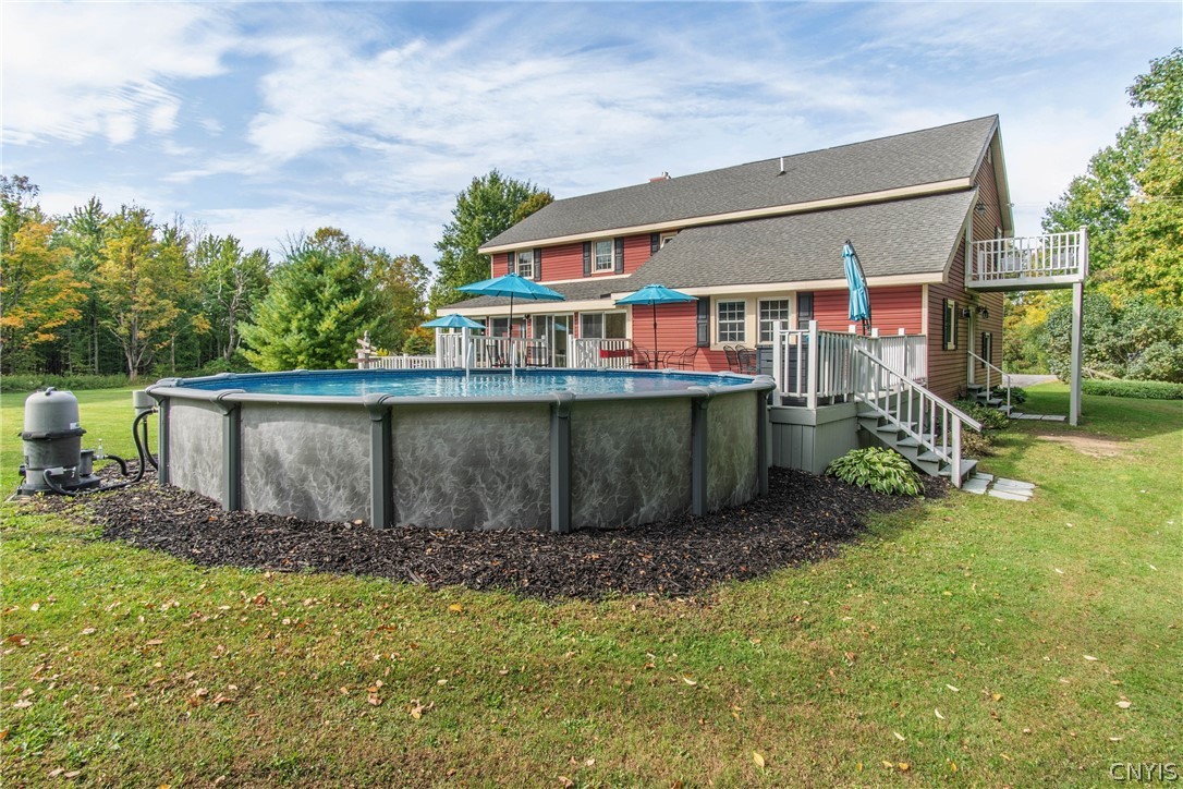 15384 Fuller Road Adams, NY 13606 - Photo 9 of 50 An inviting backyard setting features a raised swimming pool alongside a spacious deck structure.