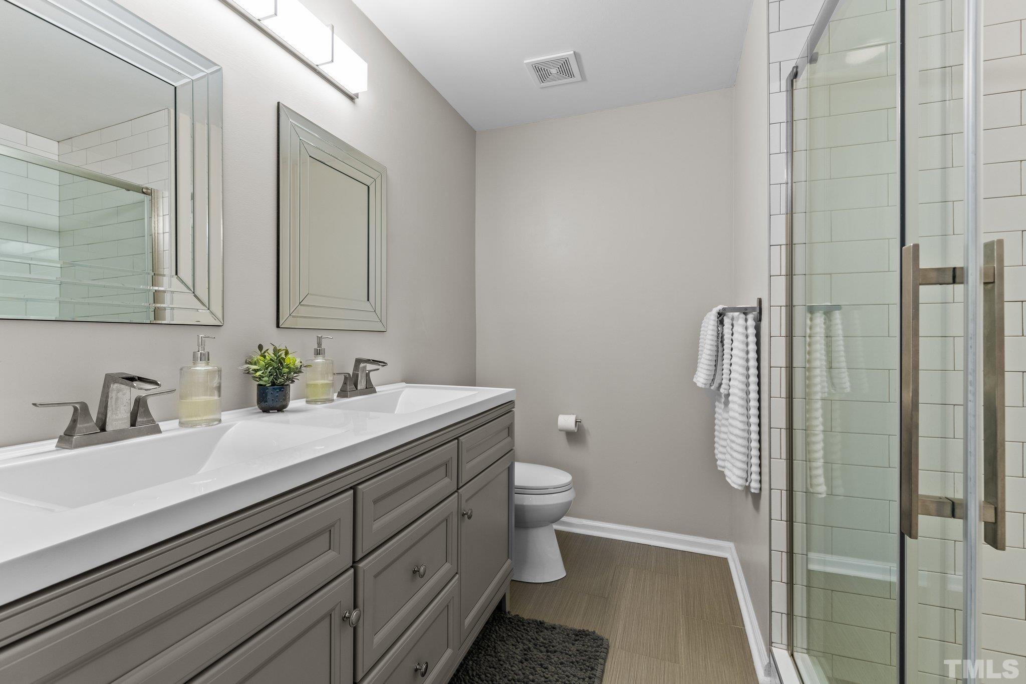 7882 Spungold Street Raleigh, NC 27617 - Photo 12 of 27 a bathroom with a sink a toilet and shower
