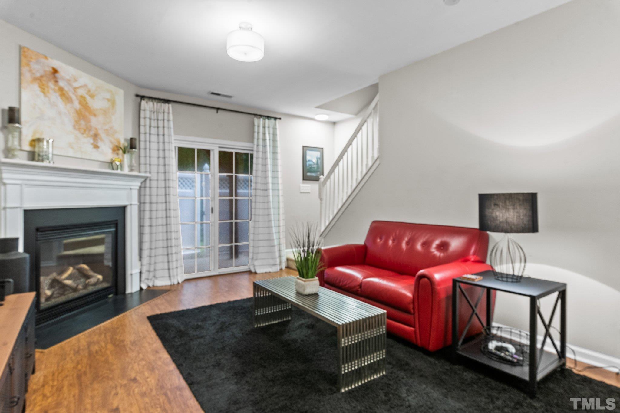 7882 Spungold Street Raleigh, NC 27617 - Photo 19 of 27 a living room with furniture a flat screen tv and a fireplace