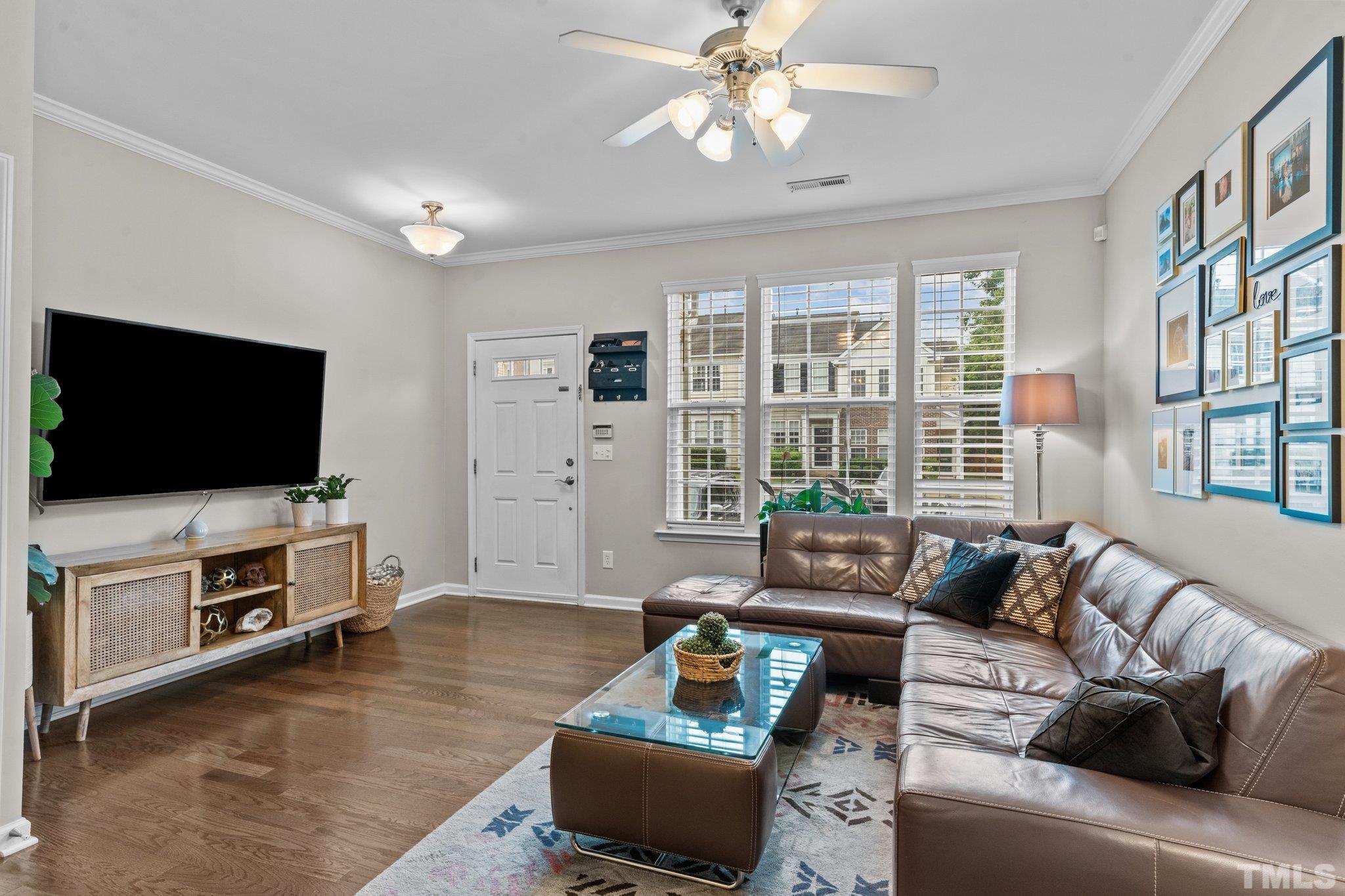 7882 Spungold Street Raleigh, NC 27617 - Photo 4 of 27 a living room with furniture and a flat screen tv