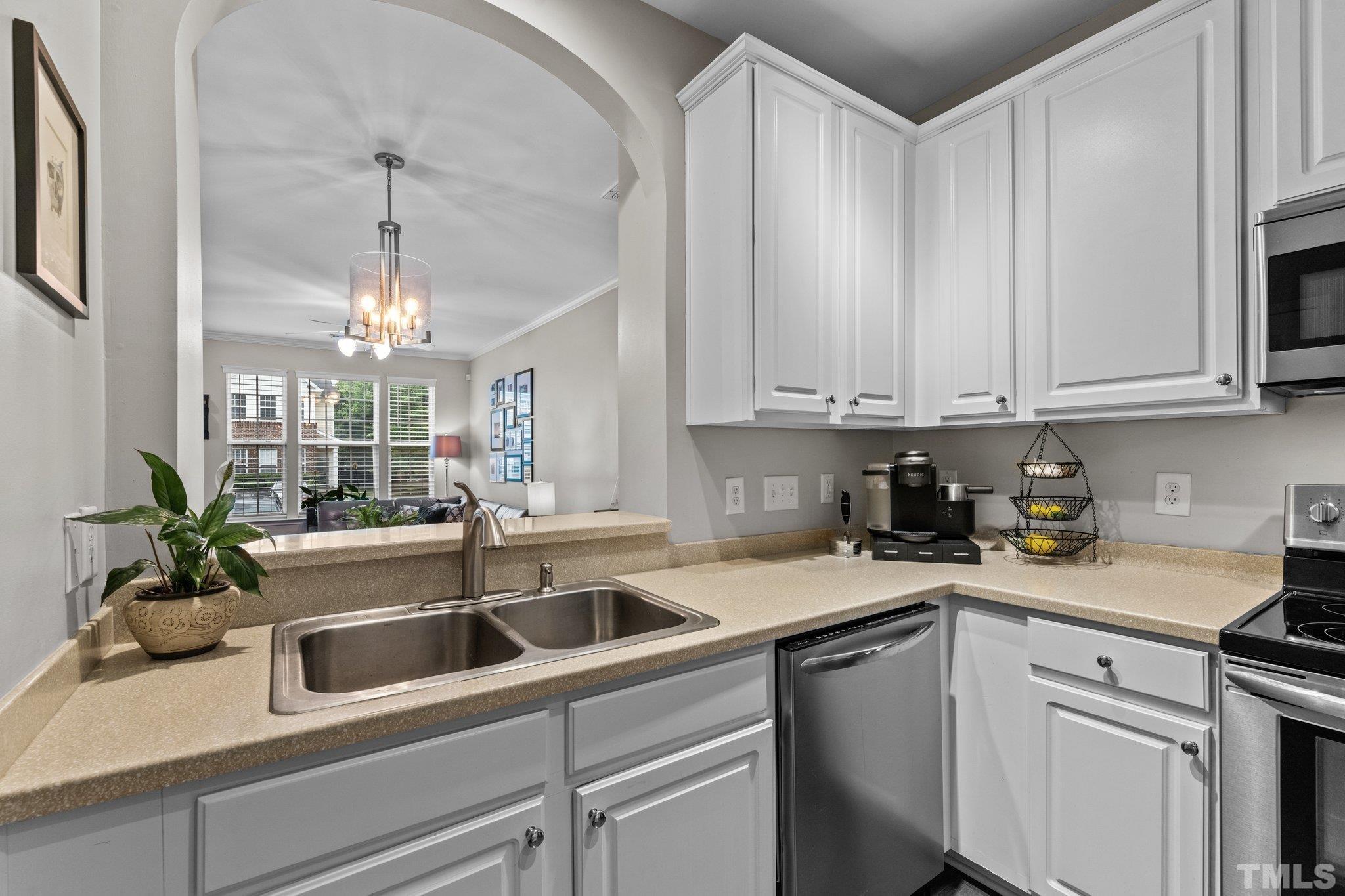 7882 Spungold Street Raleigh, NC 27617 - Photo 7 of 27 a kitchen with a sink and cabinets