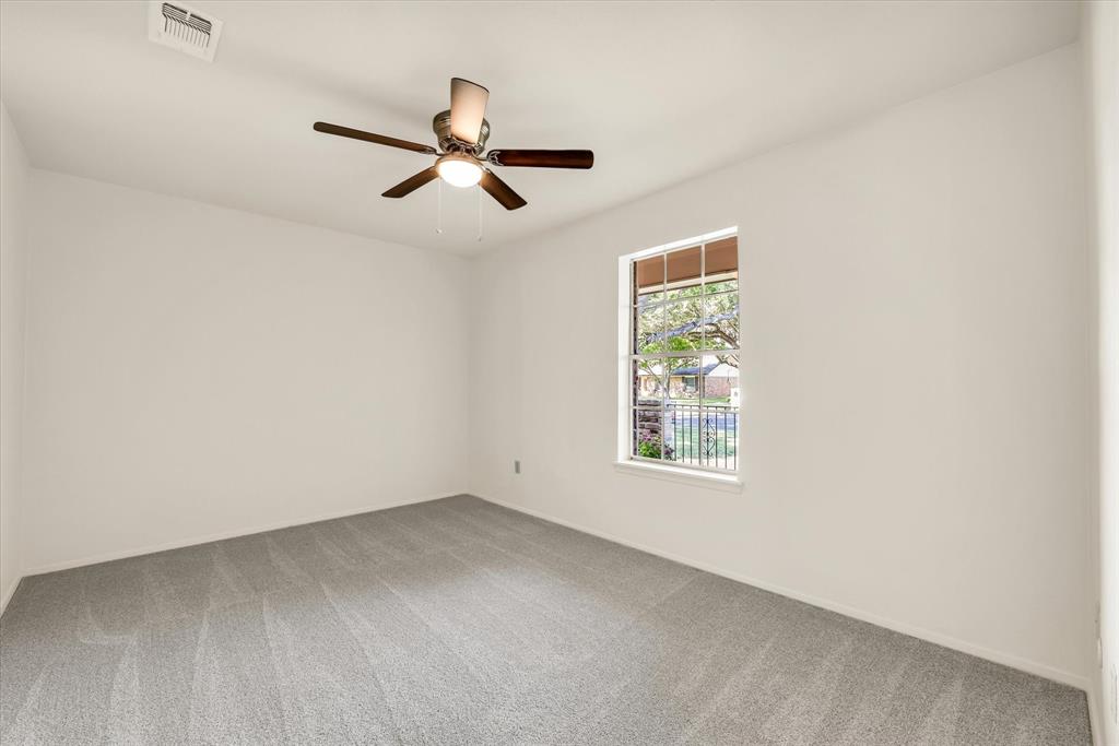 141 Travis Lane Hewitt, TX 76643 - Photo 17 of 31 Spacious room featuring light gray carpeting, a single window with white trim, a ceiling fan with integrated lighting, and white painted walls