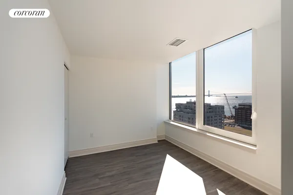 an empty room with wooden floor and windows