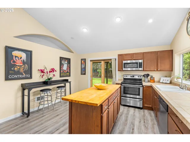 a kitchen with stainless steel appliances granite countertop a stove cabinets and wooden floor