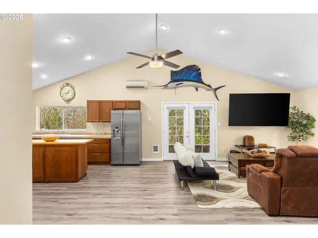 a living room with furniture a flat screen tv and kitchen view