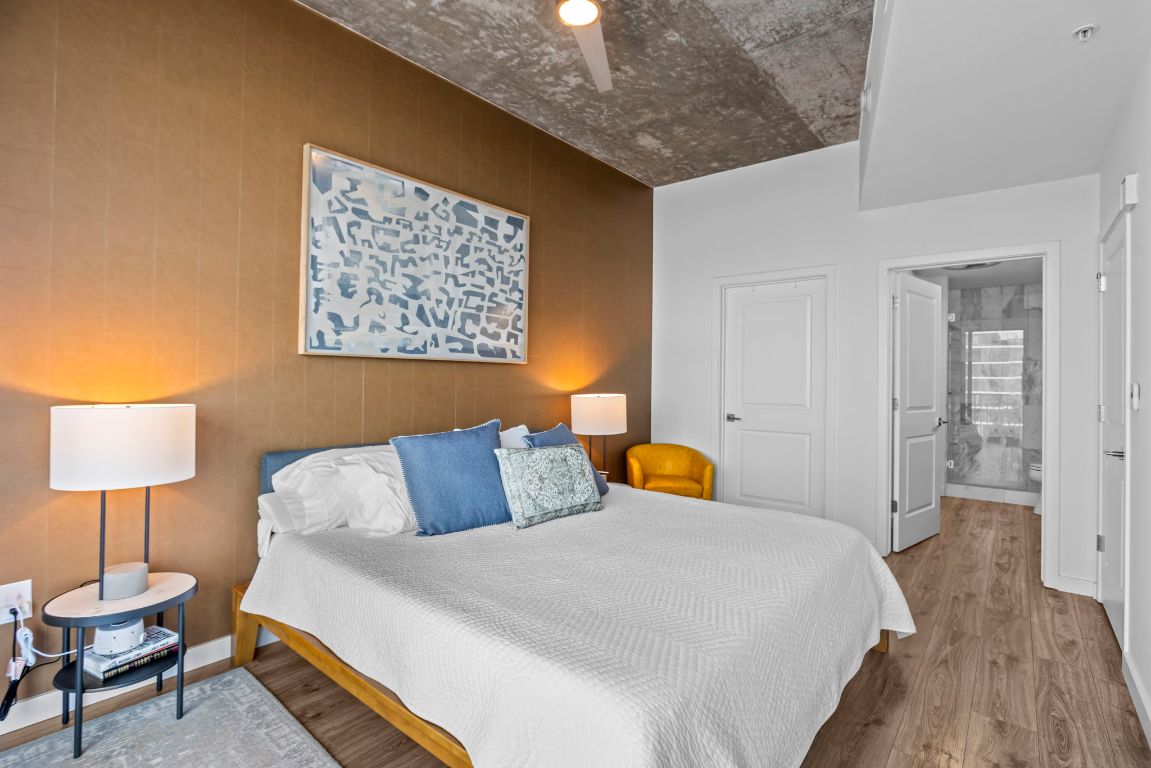 360 Nueces Street, Unit 3904 Austin, TX 78701 - Photo 12 of 32 a bedroom with a bed and a lamp