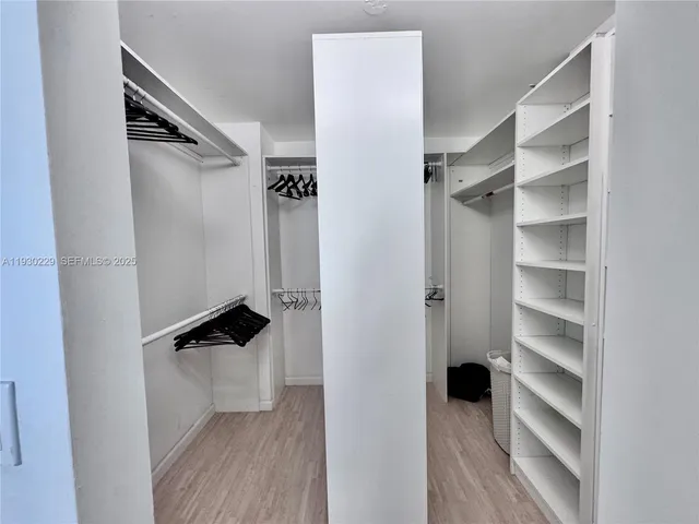 a view of walk in closet with empty racks