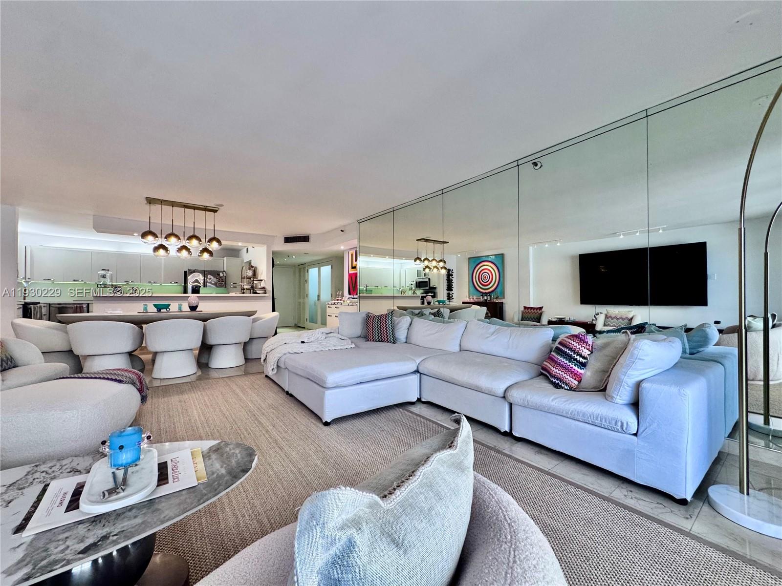 8877 Collins Avenue, Unit 402 Surfside, FL 33154 - Photo 7 of 24 a living room with furniture and a flat screen tv