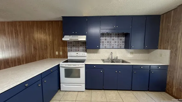 a kitchen with a sink and a stove top oven