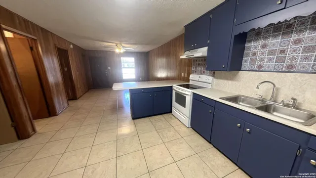 a large kitchen with stainless steel appliances granite countertop a sink stove and cabinets