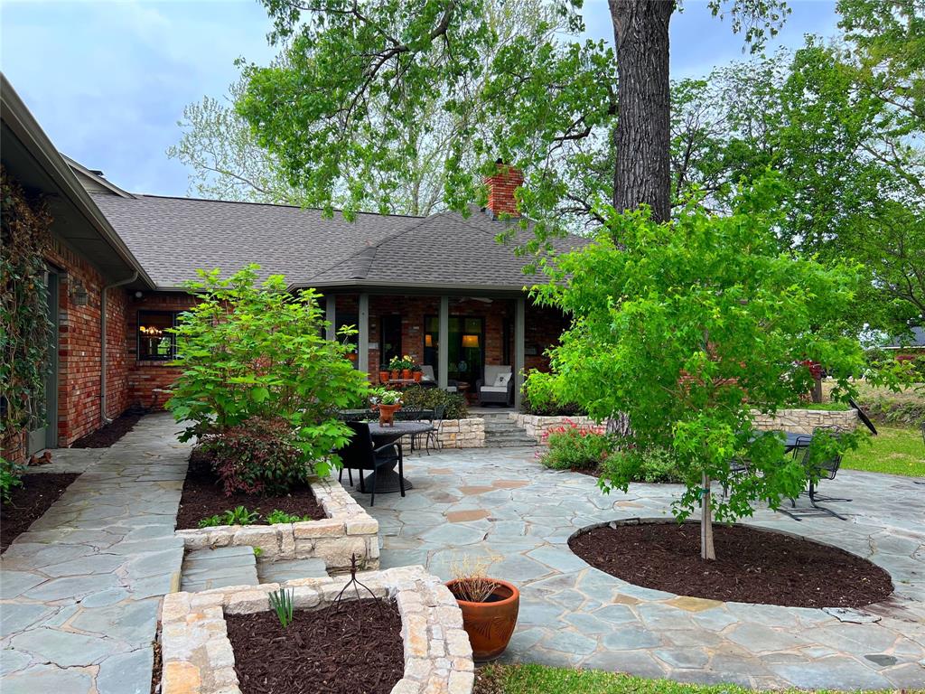 10200 North County Road Frisco, TX 75033 - Photo 3 of 25 a view of a patio with table and chairs potted plants and large tree