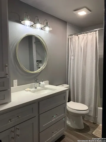 a bedroom with a bed and a flat tv screen on a dresser