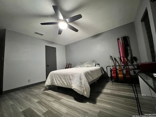 a bedroom with a bed and wooden floor