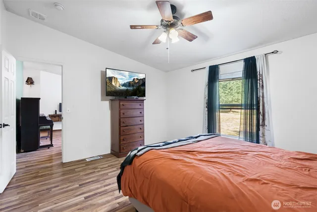 a view of an empty room with wooden floor and closet