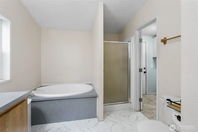 an aerial view of a house with yard and trees in the background