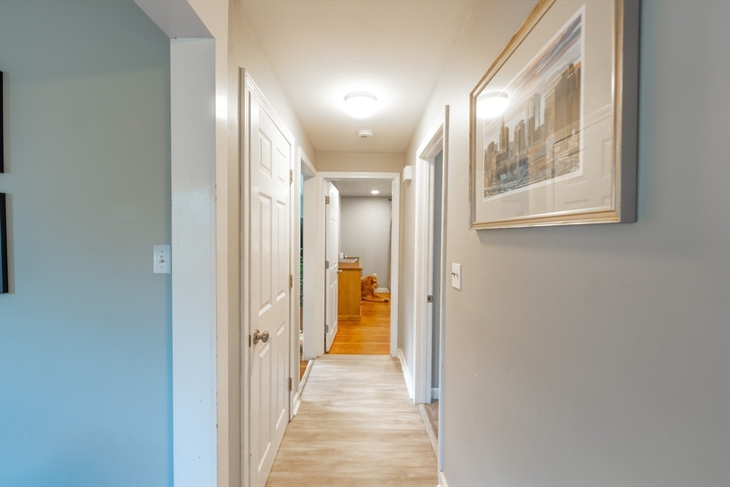 54 Chisholm Road Stoughton, MA 02072 - Photo 12 of 33 a view of a hallway with wooden floor and a bathroom