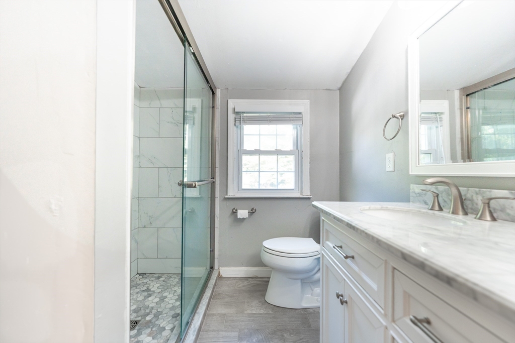 54 Chisholm Road Stoughton, MA 02072 - Photo 17 of 33 a spacious bathroom with a granite countertop sink a toilet a mirror and shower