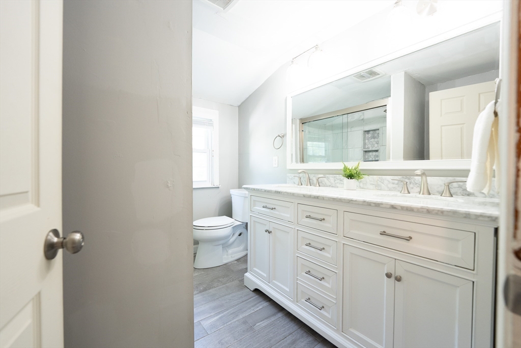 54 Chisholm Road Stoughton, MA 02072 - Photo 19 of 33 a bathroom with a granite countertop toilet sink and mirror