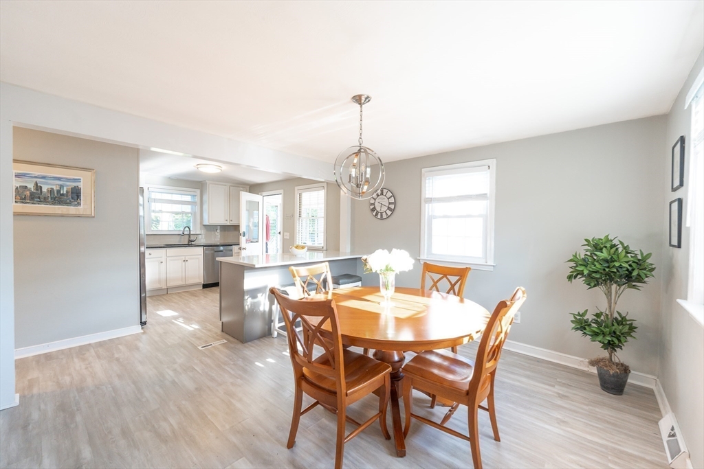 54 Chisholm Road Stoughton, MA 02072 - Photo 7 of 33 a dining room with furniture potted plants and wooden floor