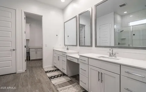 a large bathroom with a double vanity sink a large mirror and a shower