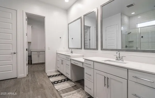 a large bathroom with a double vanity sink a large mirror and a shower