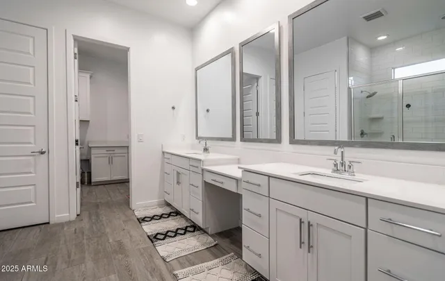 a large bathroom with a double vanity sink a large mirror and a shower