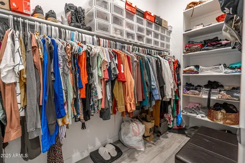 a view of walk in closet with clothes and shoes