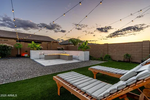 a view of a white house with a big yard and potted plants