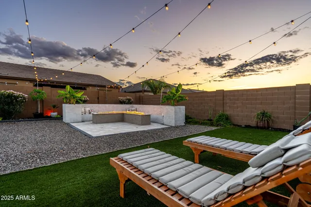 a view of a white house with a big yard and potted plants