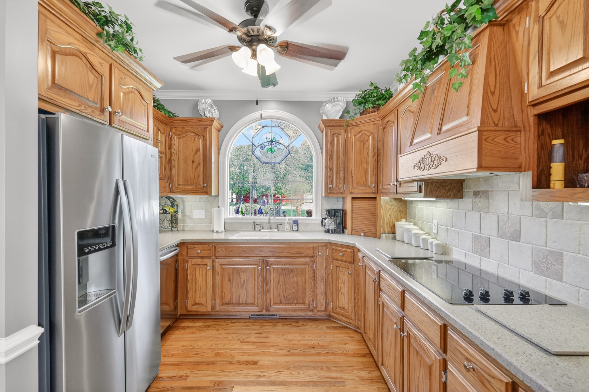 4676 Harpeth-Peytonsville Road Thompson's Station, TN 37179 - Photo 14 of 84 a kitchen with stainless steel appliances granite countertop a refrigerator a sink dishwasher a stove with wooden cabinets and floor
