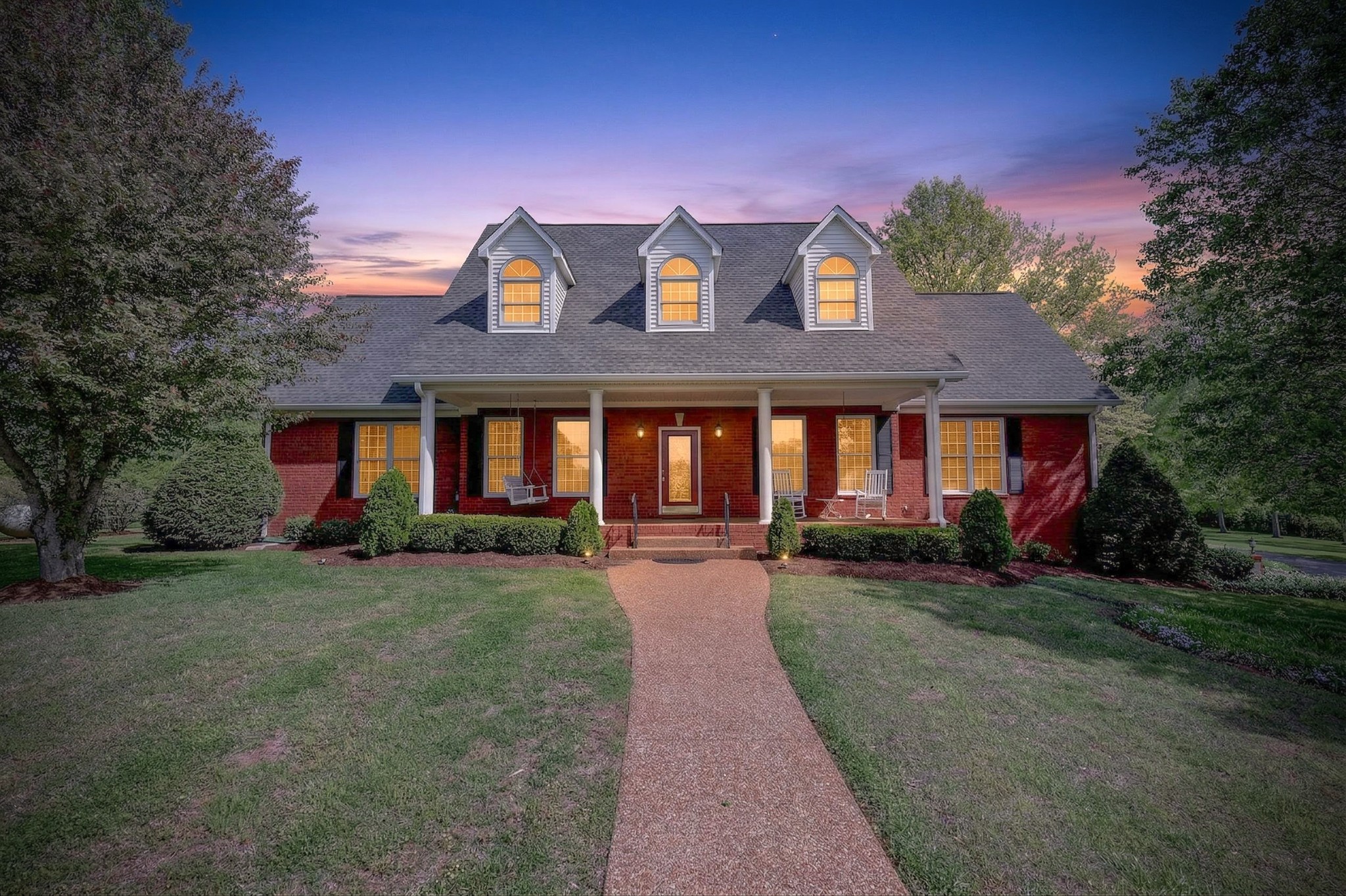 4676 Harpeth-Peytonsville Road Thompson's Station, TN 37179 - Photo 2 of 84 a view of a brick house with many windows next to a yard