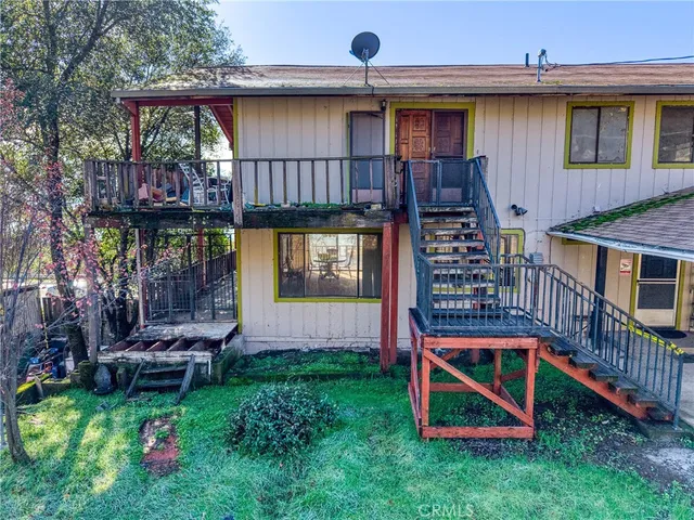 a view of a backyard with wooden fence and a porch