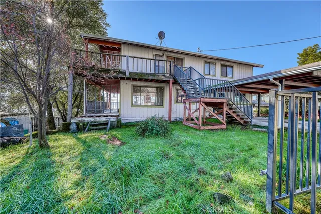 a view of a house with backyard and a tree