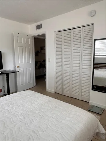 a view of a room with a bedroom and wooden floor