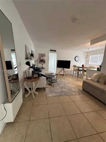 a living room with couches a computer on desk and chair