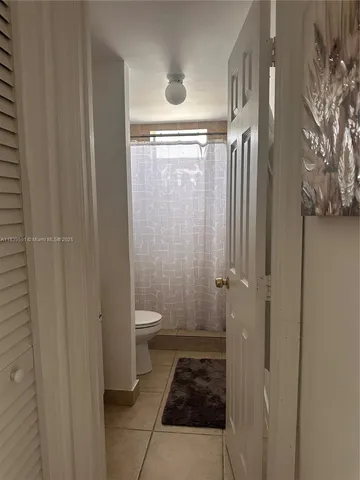a bathroom with a granite countertop shower and a toilet