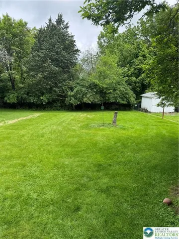 a view of field with trees in the background