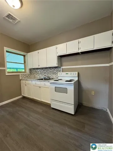 a kitchen with granite countertop white cabinets and white appliances