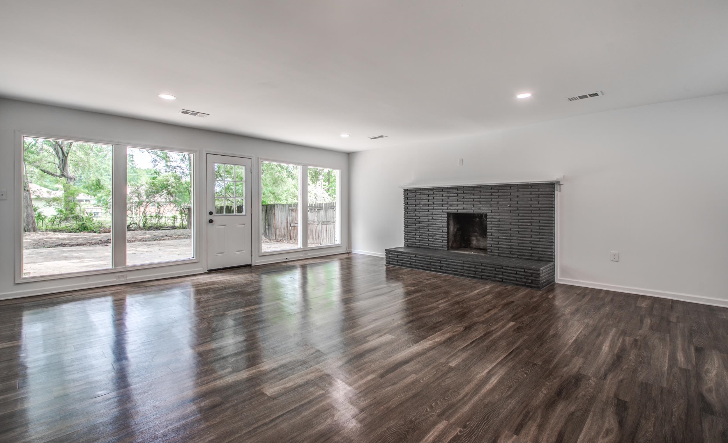 1110 Bluebird Road Memphis, TN 38116 - Photo 22 of 25 an empty room with wooden floor and fireplace