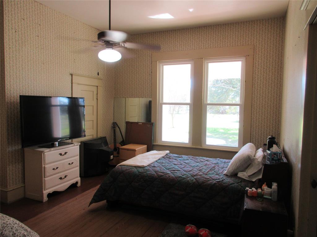 607 1st Street Rosebud, TX 76570 - Photo 17 of 29 a bedroom with a bed and a flat tv screen on dresser