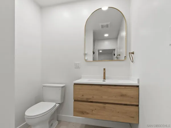 a bathroom with a sink a toilet and mirror