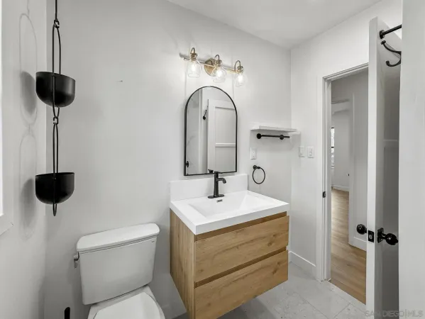 a bathroom with a sink a toilet and a mirror